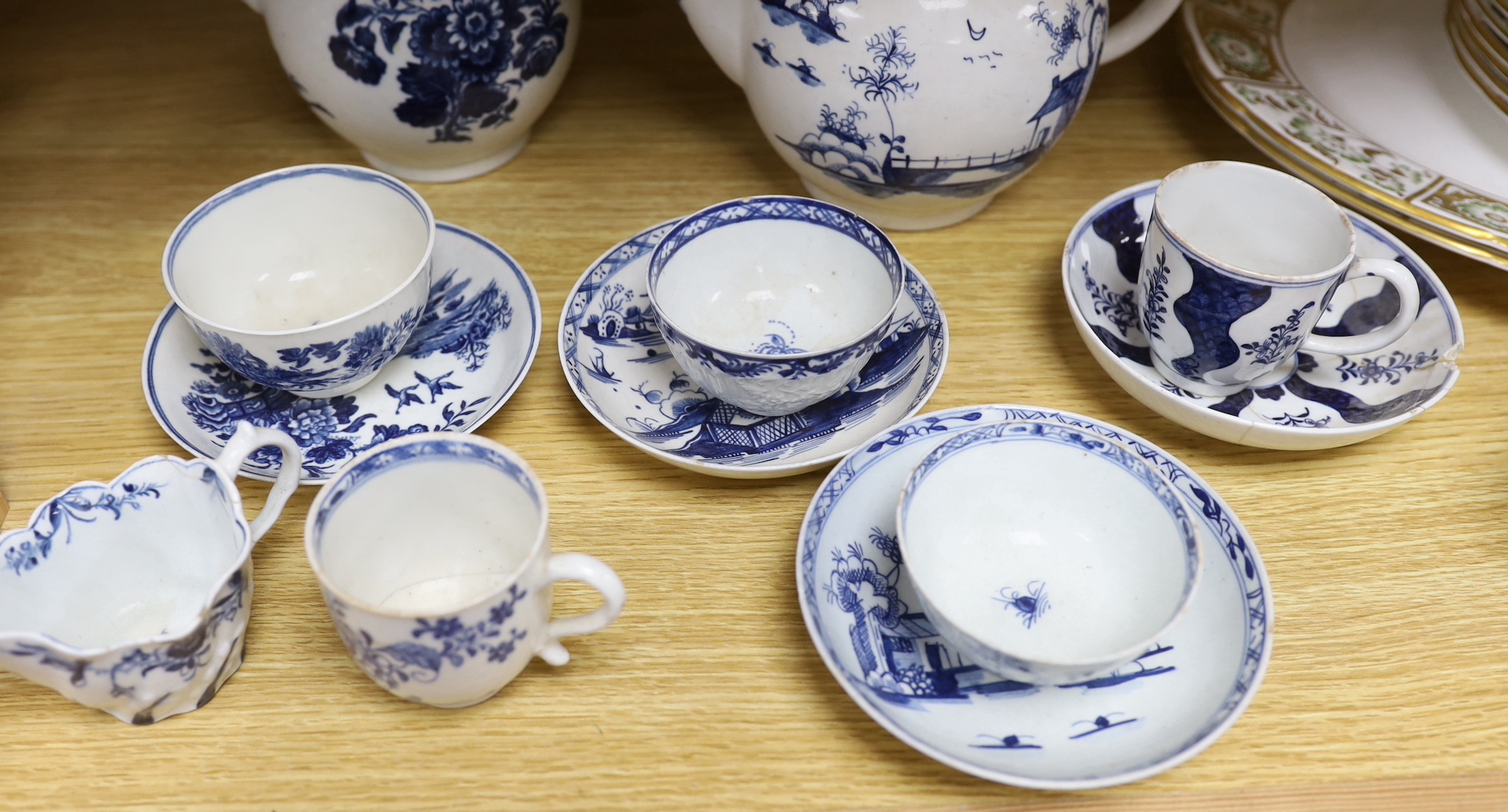 A collection of 18th century Worcester and Lowestoft blue and white tea and coffee wares, including a Lowestoft long fence pattern teapot and cover and a similar tea bowl and saucer